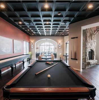 A pool table in a living room with a large window
