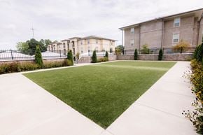 Maumelle apartment for rent - a green lawn in front of a building at The Villa at River Pointe, Arkansas, 72213