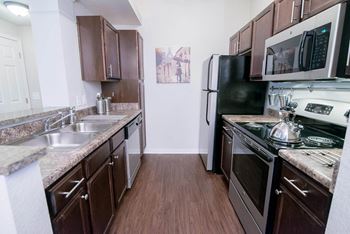 A kitchen with stainless steel appliances and marble counter tops