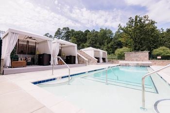 A swimming pool in front of a house with a pool