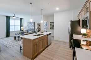 Cordova apartment for rent - A modern kitchen with wooden cabinets and a large island. at Grays Creek Apartments, Cordova, TN, 38018