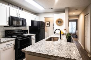 Norcross apartment for rent - Modern Kitchen with Granite Countertops and Black Appliances  at Grove Point, Norcross, GA, 30093