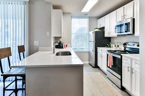 Collierville apartment for rent - an open kitchen with white cabinets and black appliances and a white counter top at Legacy Farm, Collierville, Tennessee