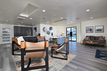 Houston apartment for rent - A modern living room with a grey sofa and a wooden chair.