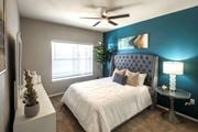 Memphis apartment for rent - A bedroom with a white bed and a blue headboard. at Park at Forest Hill Apartments, Memphis