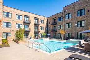 Southaven apartment for rent - A swimming pool is surrounded by a patio area and chairs.