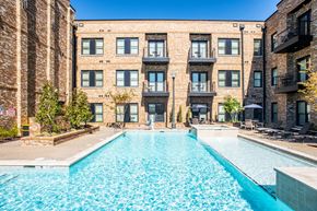 Southaven apartment for rent - A swimming pool in front of a brick building.