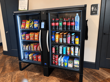 Lewisville apartment for rent - A black vending machine with a variety of snacks and drinks inside.