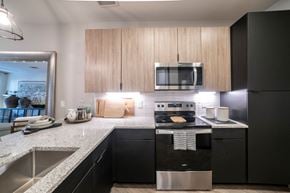 Lewisville apartment for rent - a kitchen with black appliances and granite counter tops at Station at Old Town, Lewisville, TX