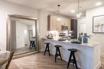 A kitchen with a bar and stools in a house
