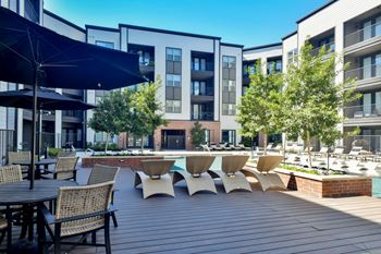 A large patio with tables and chairs and a swimming pool