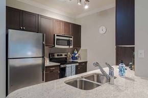 Atlanta apartment for rent - A kitchen with a stainless steel refrigerator and a microwave oven. at The Ren, Georgia, 30329