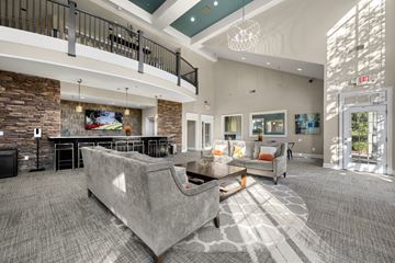 Duluth apartment for rent - A living room with a grey couch and a stone wall.
