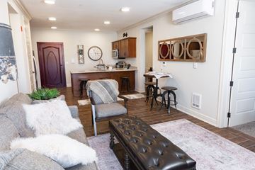 Overland Park apartment for rent - A living room with a grey couch and a black leather ottoman.