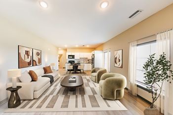 A modern living room with a white sofa, a coffee table, and a potted plant.