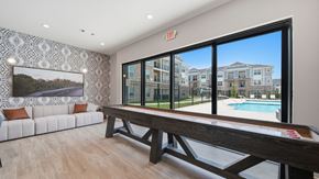 Millington apartment for rent - A room with a pool table and a view of a pool and apartment buildings.