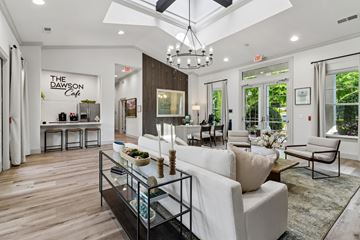 Cartersville apartment for rent - A modern living room with a white sofa and a glass coffee table.
