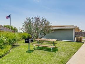 Oklahoma City apartment for rent - A picnic table is in the grass next to a mailbox and a tree.