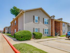 Oklahoma City apartment for rent - A row of houses with a blue car parked in front of the last one.