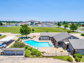 Oklahoma City apartment for rent - A large building with a pool in front.