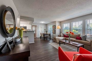 Louisville apartment for rent - A modern living room with a red chair and a wooden table.