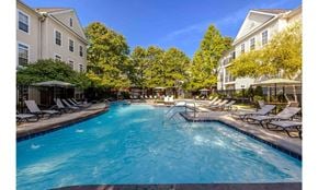 Columbus townhouse for rent - A swimming pool surrounded by lounge chairs and trees.