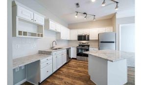 Columbus townhouse for rent - A modern kitchen with white cabinets and a marble countertop.