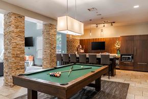 Louisville apartment for rent - A pool table with a green cloth and a cue stick on it.