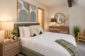 Akron apartment for rent - A bedroom with a bed, nightstand, and a plant.