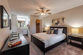 Louisville apartment for rent - A bedroom with a bed, nightstand, and a ceiling fan.