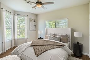 Fort Worth townhouse for rent - A bedroom with a large bed and a ceiling fan.
