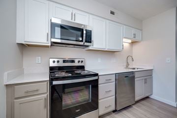 Middletown apartment for rent - A kitchen with white cabinets and a stove top oven.