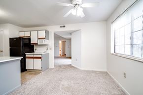 Cincinnati apartment for rent - A kitchen with white cabinets and a black fridge is seen.