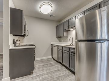Oklahoma City apartment for rent - A kitchen with a stainless steel refrigerator and a dishwasher.