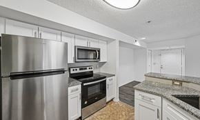 West Palm Beach apartment for rent - A kitchen with a stainless steel refrigerator and a microwave above the stove.
