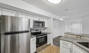 West Palm Beach apartment for rent - A kitchen with a stainless steel refrigerator and a microwave above the stove.
