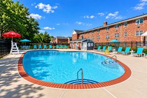 Lansdale apartment for rent - A swimming pool surrounded by chairs and umbrellas.
