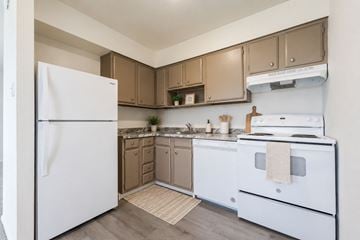 Horsham apartment for rent - A white refrigerator stands in a kitchen with brown cabinets and a white stove.