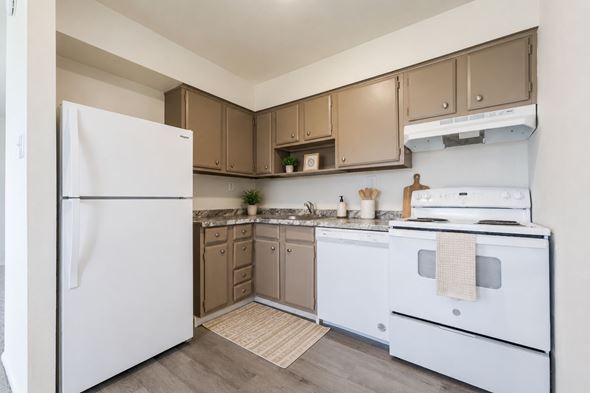 Horsham apartment for rent - A white refrigerator stands in a kitchen with brown cabinets and a white stove.