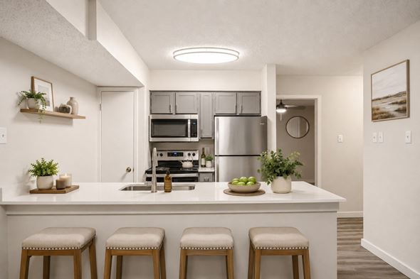 Irving townhouse for rent - A kitchen with white cabinets and a white island with three stools.