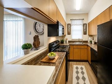 Fort Wayne townhouse for rent - A kitchen with wooden cabinets and a black refrigerator.