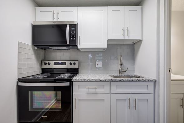 Rosedale apartment for rent - A kitchen with a black stove top oven and white cabinets.
