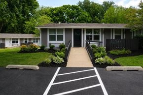 Tallahassee apartment for rent - A house with a driveway and landscaping in front.