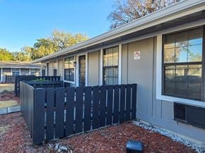 Gainesville apartment for rent - A black fence in front of a building with a red square on the door.