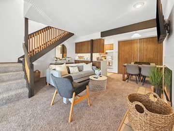 Akron apartment for rent - A living room with a grey couch and a wooden chair.