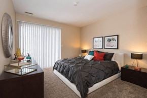 Manchester apartment for rent - A bedroom with a large bed, a dresser, and a mirror.