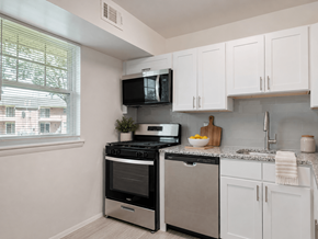 Claymont apartment for rent - A kitchen with white cabinets and a black stove top oven.