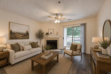 Fayetteville apartment for rent - A living room with a fireplace, a couch, a chair, a coffee table, and a painting on the wall.
