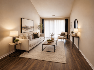 South Bend apartment for rent - A living room with a white couch, a coffee table, and a painting on the wall.