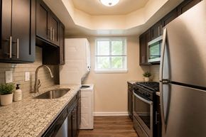 Glen Burnie apartment for rent - A kitchen with a stainless steel refrigerator and black cabinets.